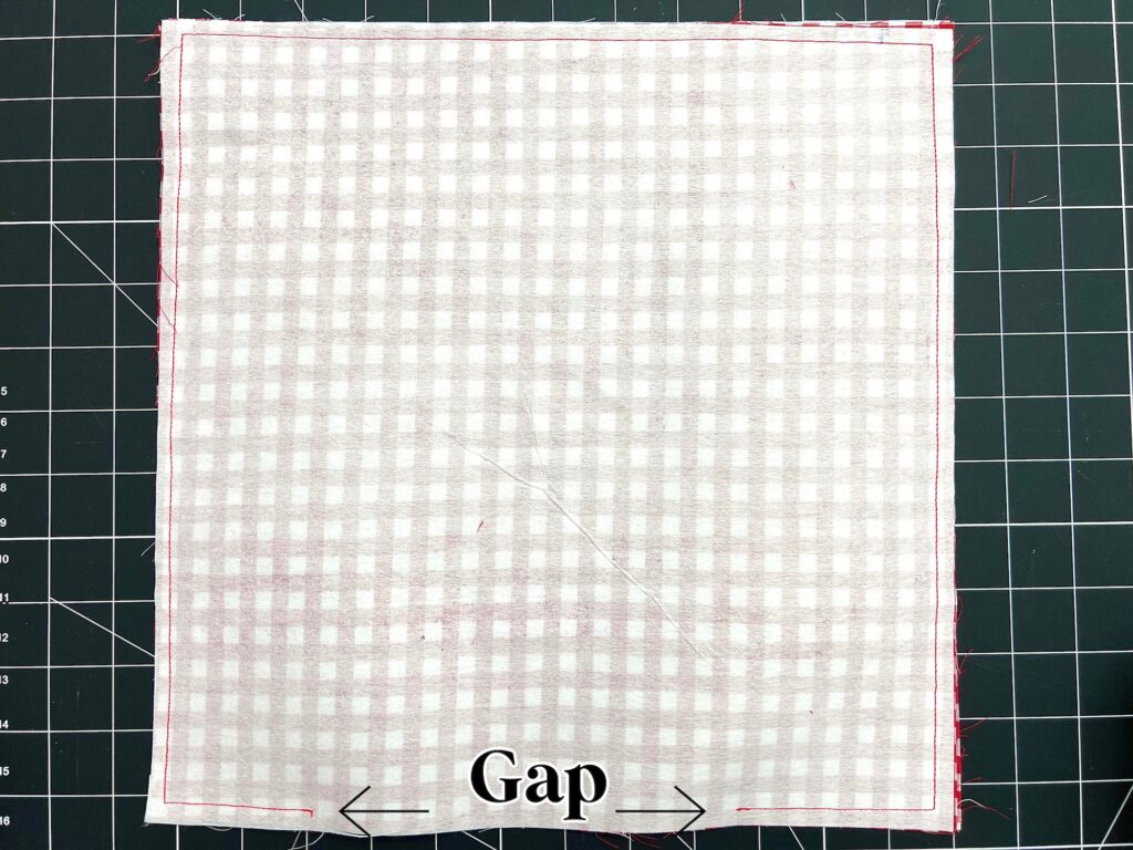 A square piece of fabric with a checkered pattern is stitched around the edges, leaving a gap at the bottom marked with arrows and the word "Gap.