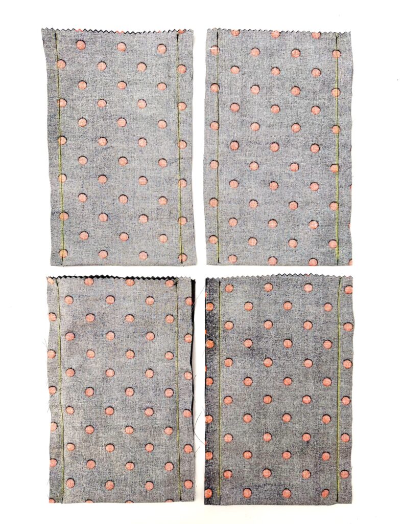Four rectangular pieces of gray fabric with pink dots, each with stitched edges, are arranged in a grid on a white background.