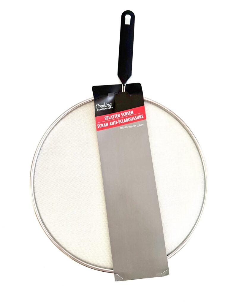 A metal splatter screen with a black handle and product label, designed to cover pans and prevent oil splashes while cooking—an essential tool, whether you’re frying dinner or creating treats for your Halloween wreath party.