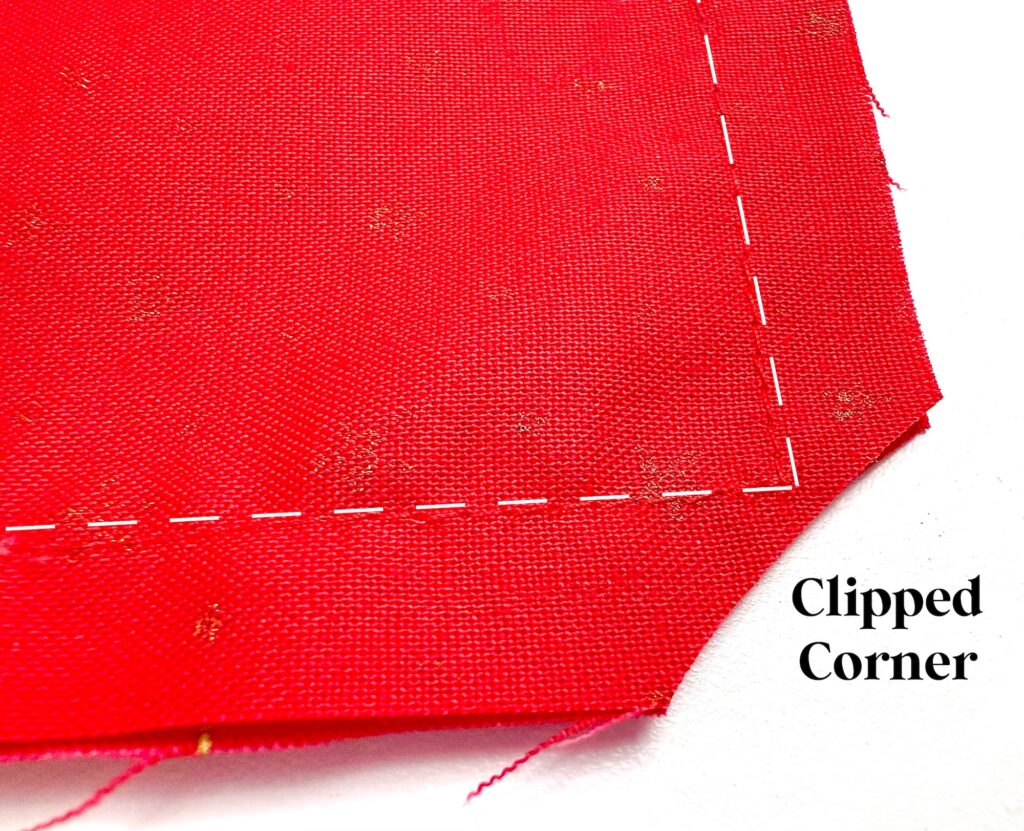 A red fabric with a stitched seam and one corner cut off, labeled "Clipped Corner" on a white background.