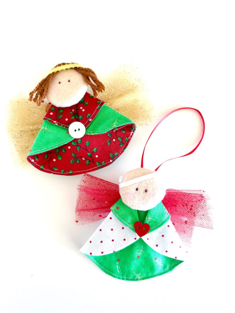Two handmade angel ornaments with fabric dresses, button decorations, yarn or felt hair, and tulle wings, displayed on a white background.