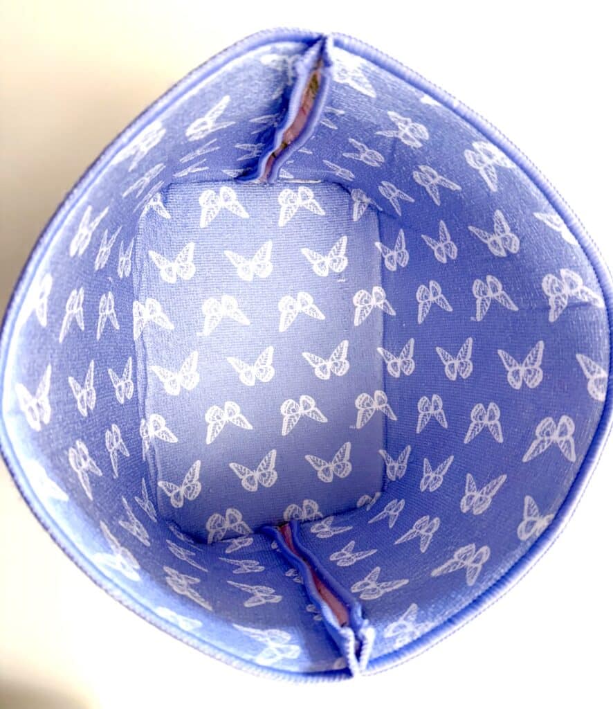 Top view of a blue fabric box with white butterfly patterns and reinforced corners.