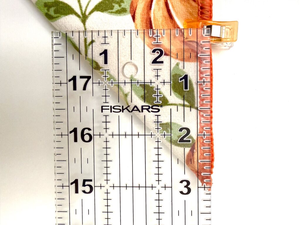 clear acrylic ruler measuring three inches along the edge of a drying mat decorated with pumpkins