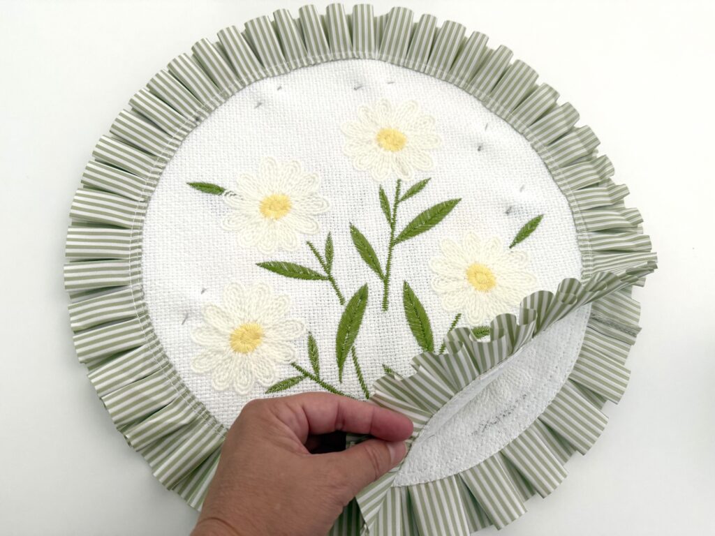 hand holding open the gap between two placemats sewn together to create an inexpensive throw pillow