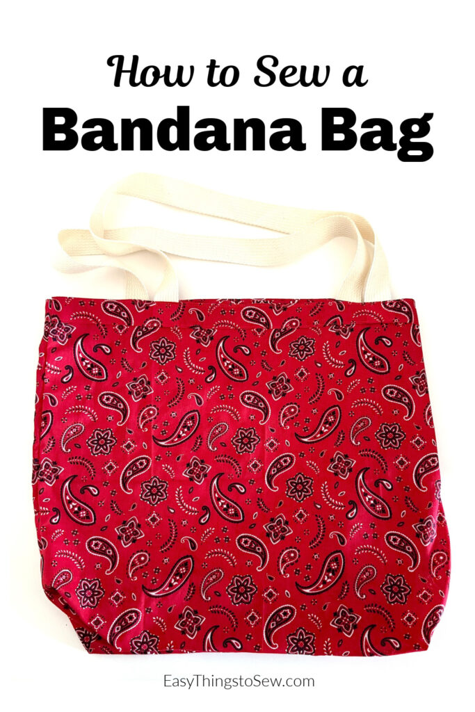 Red bandana-patterned fabric tote bag with white straps, shown on a white background. Text above reads “How to Sew a Bandana Bag,” highlighting this stylish and practical bandana bag design.