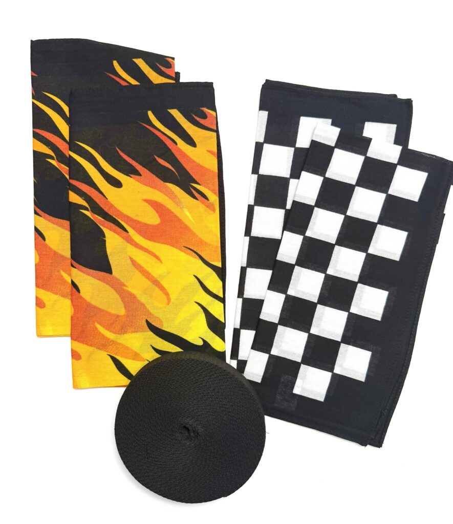 Two yellow and orange flame-patterned cloths, two black and white checkered cloths, and a roll of black elastic ribbon are arranged on a white background—perfect components for creating your own custom bandana bag.