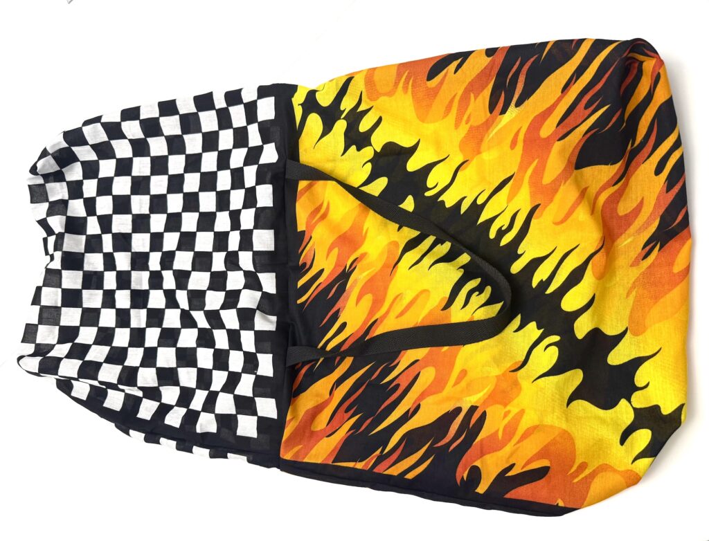 A bandana bag featuring two eye-catching patterns: black and white checkers on one side and vibrant yellow, orange, and black flames on the other.