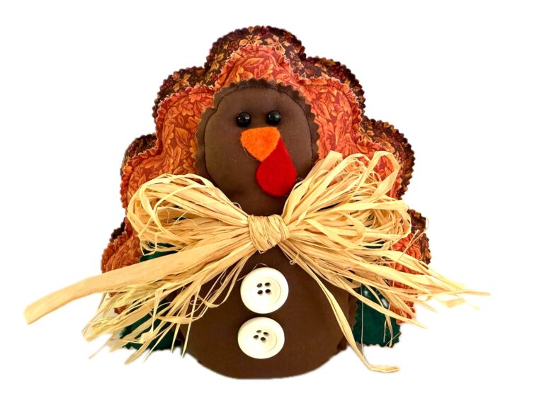 Handmade Fabric turkey decoration with a raffia bow and two white buttons on its chest.