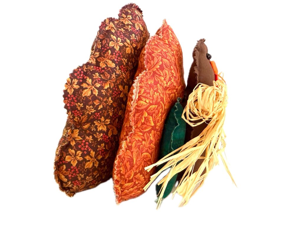 A handcrafted turkey decoration made with fabric leaves and a raffia fringe.